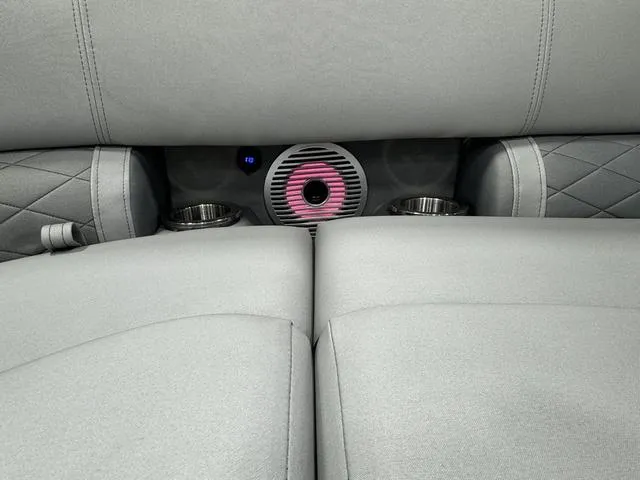 Slide: The Image of 2024 Bennington 23 LSB interior with gray upholstery, cup holders, and speaker. - 27