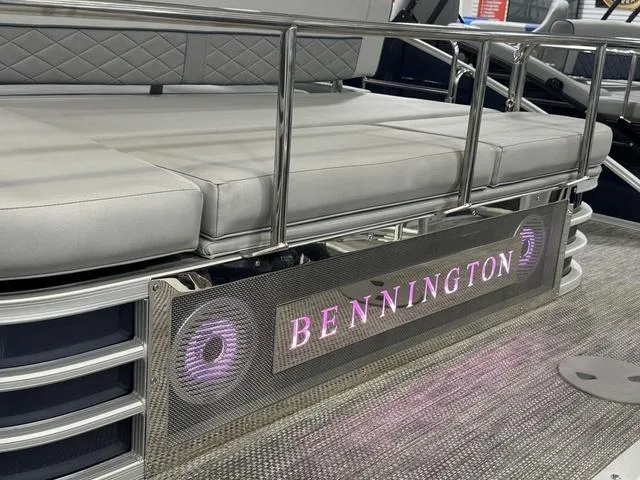Slide: The Image of 2024 Bennington 23 LSB pontoon boat with illuminated logo and cushioned seating. - 33