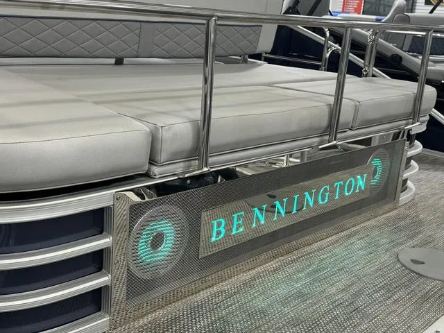 Slide: The Image of 2024 Bennington 23 LSB pontoon boat with illuminated logo and cushioned seating. - 35