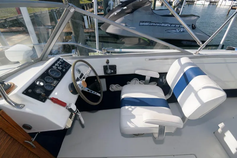Slide: The Image of 1972 Chris-Craft Lancer 23 boat cockpit with steering wheel and white seats. - 10