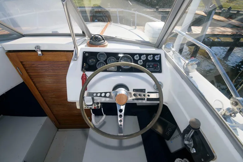 Slide: The Image of 1972 Chris-Craft Lancer 23 boat helm with wooden steering wheel and control panel. - 6