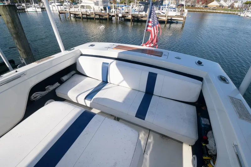 Slide: The Image of 1972 Chris-Craft Lancer 23 boat with white and blue seating, docked at a marina. - 8