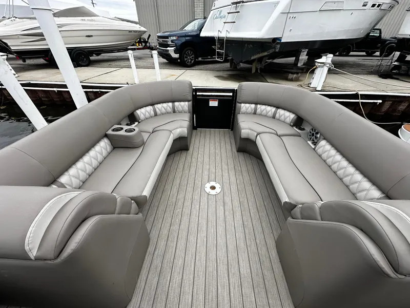 Slide: The Image of 2018 Bennington G25 pontoon boat with luxurious seating at a marina. - 1