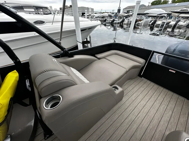 Slide: The Image of 2018 Bennington G25 boat interior with luxurious seating at a marina. - 10