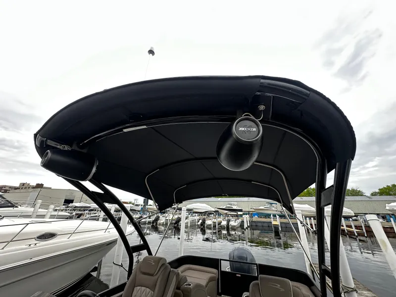 Slide: The Image of 2018 Bennington G25 pontoon boat with canopy and speakers at a marina. - 12