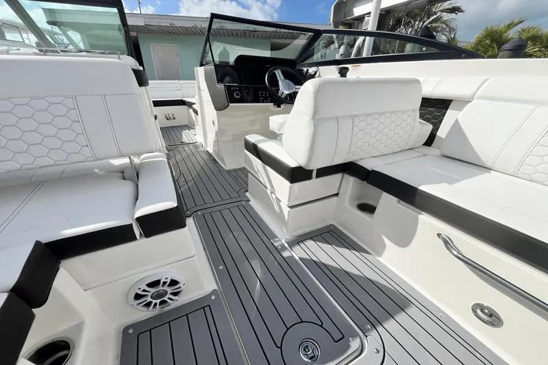 Slide: The Image of 2019 Sea Ray SDX 270 Outboard boat interior with white seating and gray flooring. - 10