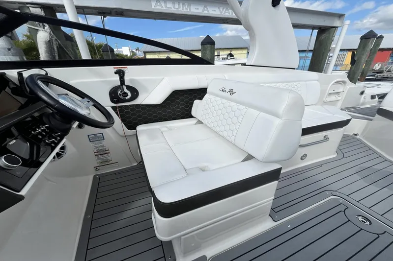 Slide: The Image of 2019 Sea Ray SDX 270 Outboard boat interior with white seating and steering wheel. - 14