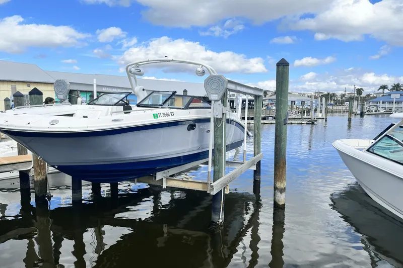 Slide: The Image of 2019 Sea Ray SDX 270 Outboard boat docked at a marina under a blue sky. - 2