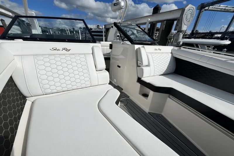 Slide: The Image of 2019 Sea Ray SDX 270 Outboard boat interior with white seating and hexagonal pattern. - 26