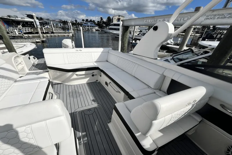 Slide: The Image of 2019 Sea Ray SDX 270 Outboard boat interior with white seating and dock view. - 29