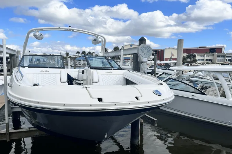 Slide: The Image of 2019 Sea Ray SDX 270 Outboard boat docked at a marina under a blue sky. - 3