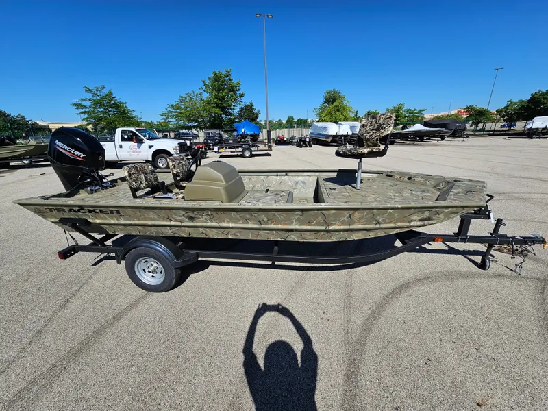Slide: The Image of 2024 Tracker Grizzly 1754 SC boat on a trailer in a parking lot. - 2
