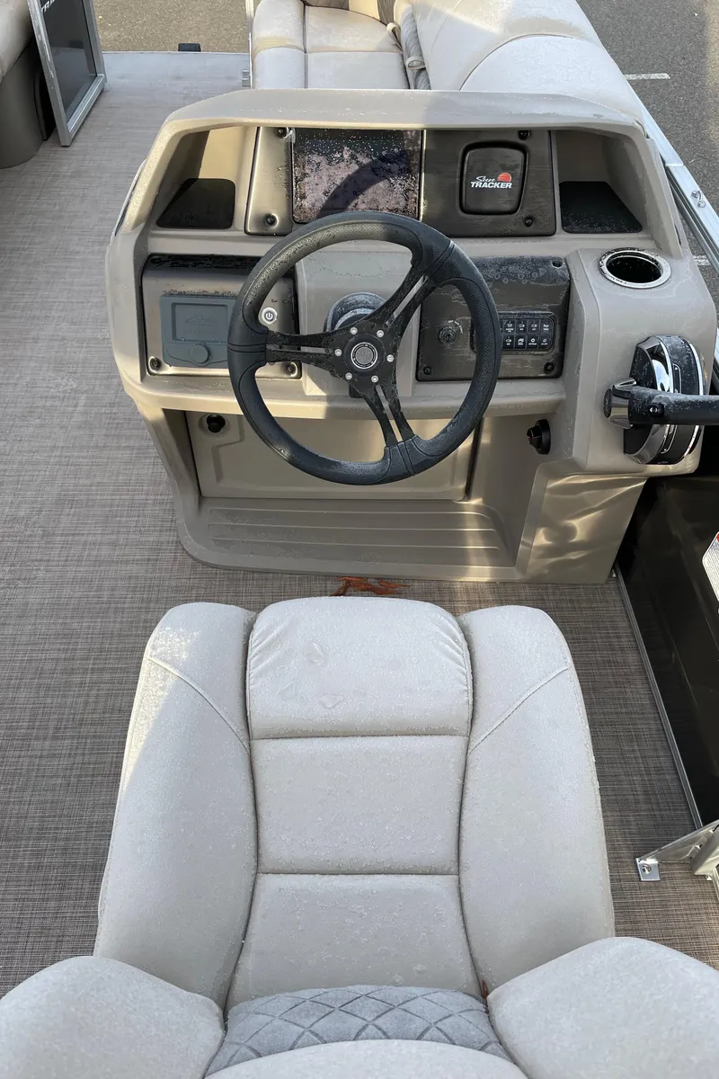 Slide: The Image of 2024 Sun Tracker Party Barge 20 DLX helm with steering wheel and control panel. - 4