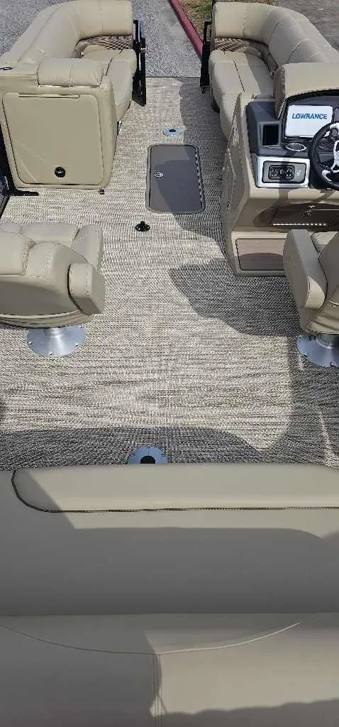 Slide: The Image of 2024 Regency 250 DL3 pontoon boat interior with beige seating and modern dashboard. - 4