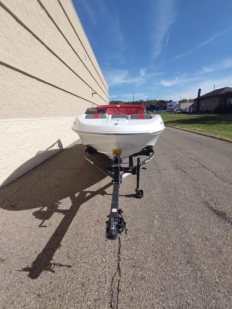 Slide: The Image of 2024 Tahoe T16 boat on trailer, parked outdoors under clear blue sky. - 3