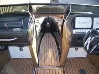 Slide: The Image of Interior of 2024 Crownline 240LPX boat with modern dashboard and wooden flooring. - 9
