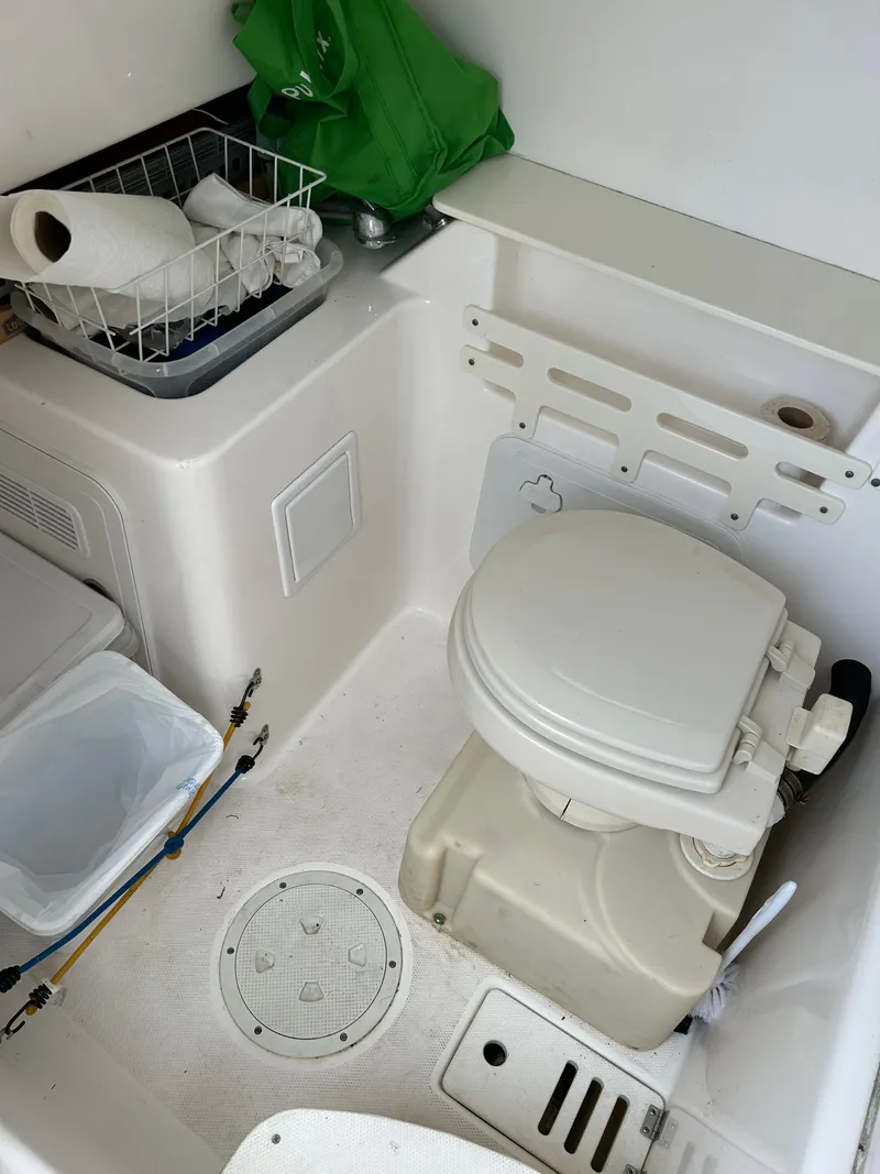 Slide: The Image of 2012 Everglades 295 Center Console boat interior with marine toilet and storage. - 8