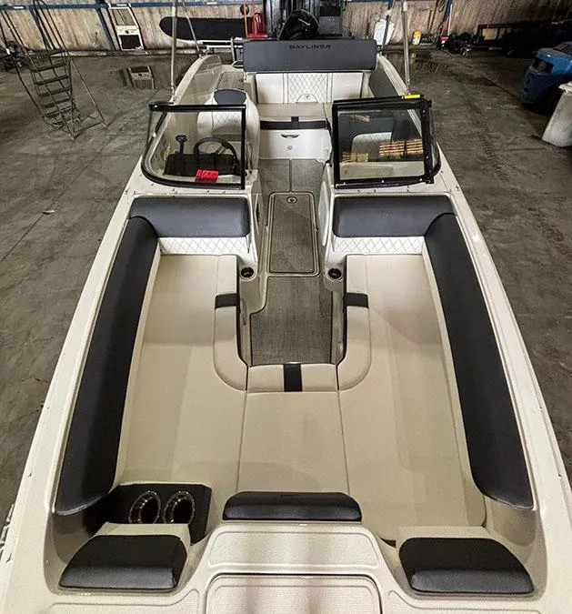 Slide: The Image of 2024 Bayliner DX 2000 boat interior with seating and steering console. - 13