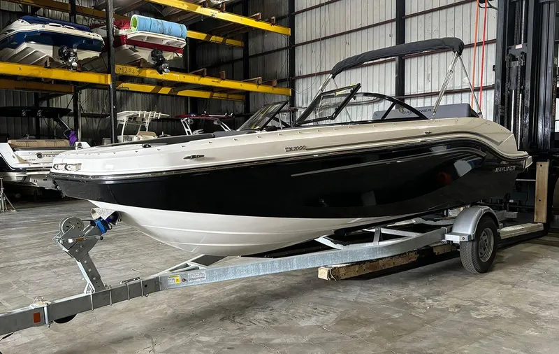 Slide: The Image of 2024 Bayliner DX 2000 boat on a trailer in a storage facility. - 3