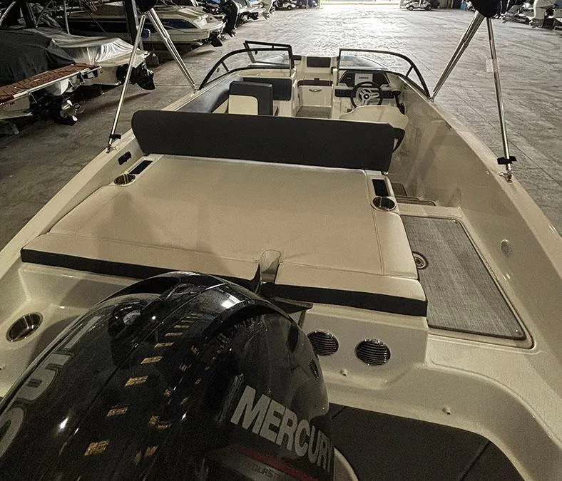 Slide: The Image of 2024 Bayliner DX 2000 boat interior with Mercury outboard engine in storage. - 4