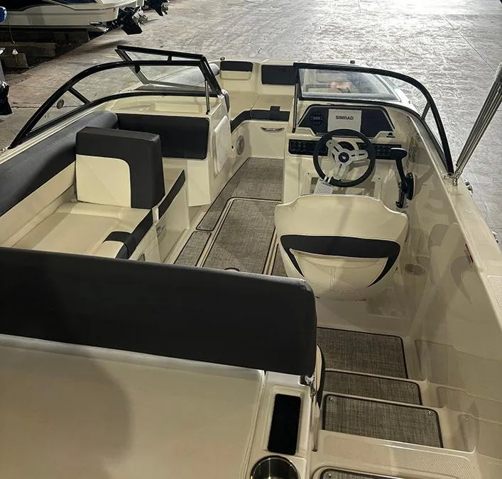 Slide: The Image of 2024 Bayliner DX 2000 boat interior with seating and steering console. - 5