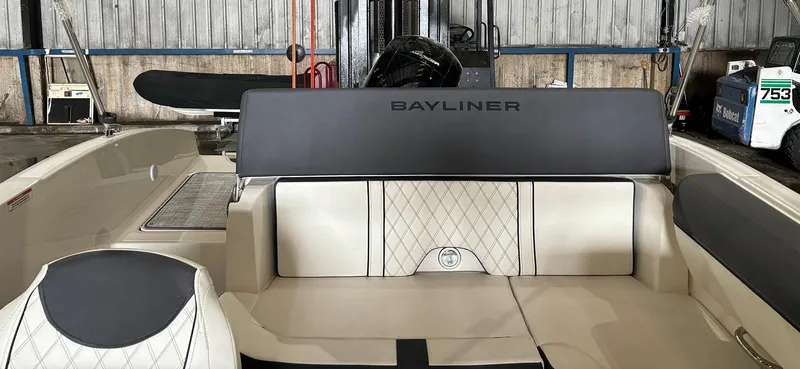 Slide: The Image of 2024 Bayliner DX 2000 boat interior with cushioned seating in a storage facility. - 8