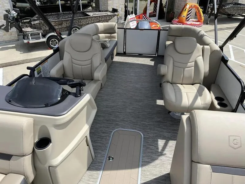 Slide: The Image of 2023 Godfrey Sweetwater 2286SB pontoon boat interior with beige seating and helm. - 12