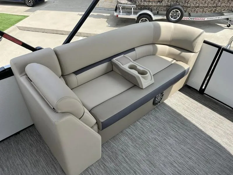 Slide: The Image of 2023 Godfrey Sweetwater 2286SB boat interior with beige seating and cup holders. - 15