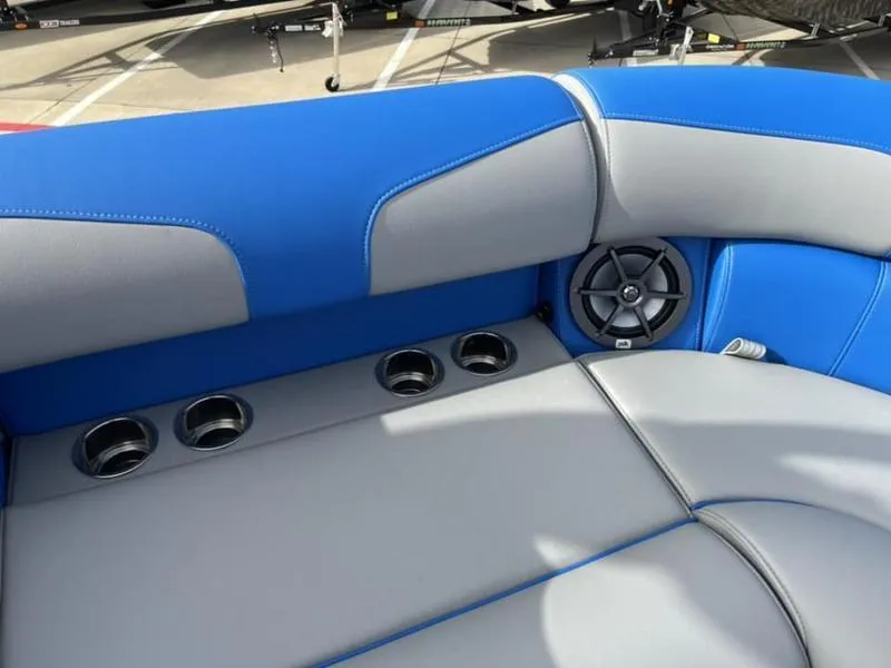 Slide: The Image of 2023 Montara Surf Boss boat interior with blue and gray seating, cup holders, and speaker. - 19