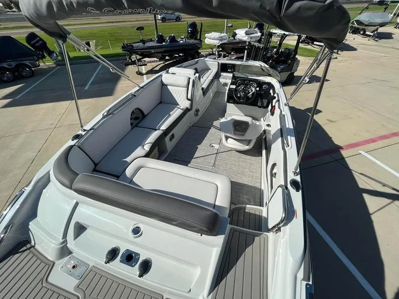 Slide: The Image of 2023 Crownline E205XS boat interior with seating and steering console. - 10
