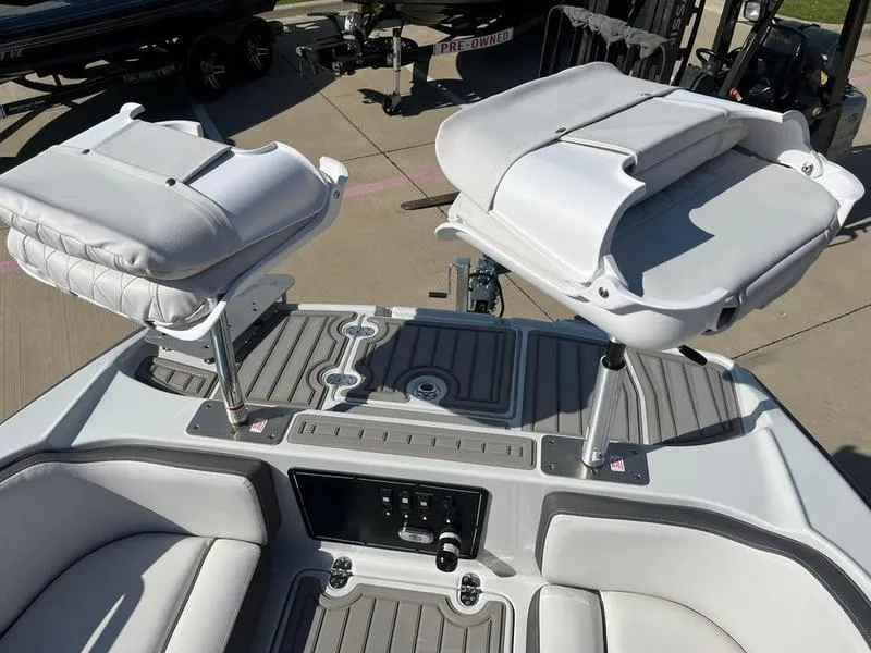 Slide: The Image of 2023 Crownline Boats E205XS interior with adjustable seats and control panel. - 15