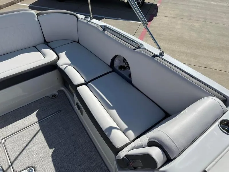 Slide: The Image of 2023 Crownline E205XS boat interior with gray cushioned seating and carpeted floor. - 17