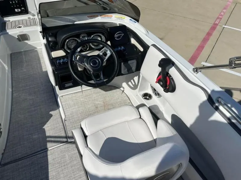 Slide: The Image of 2023 Crownline E205XS boat cockpit with steering wheel and seating. - 20