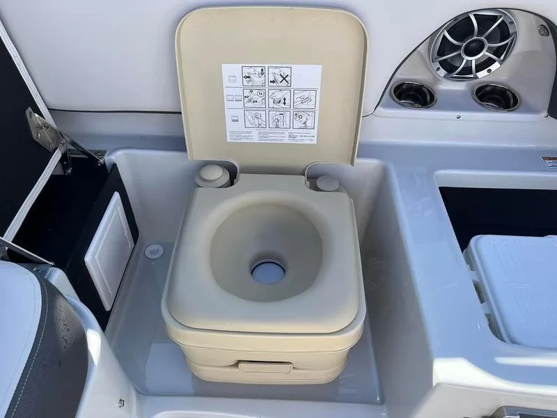 Slide: The Image of 2023 Crownline E205XS boat with built-in portable toilet and speaker system. - 25
