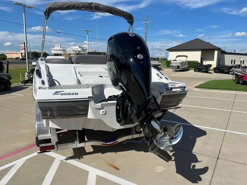 Slide: The Image of 2023 Crownline E205XS boat with outboard motor in a parking lot. - 8