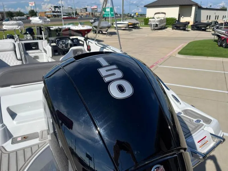 Slide: The Image of 2023 Crownline E205XS boat with 150 horsepower engine in a dealership lot. - 9