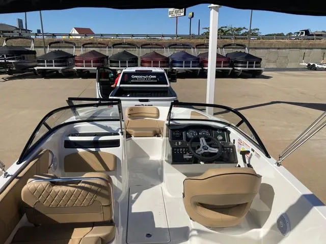 Slide: The Image of 2023 Bayliner VR5 boat interior with tan seats and dashboard. - 3