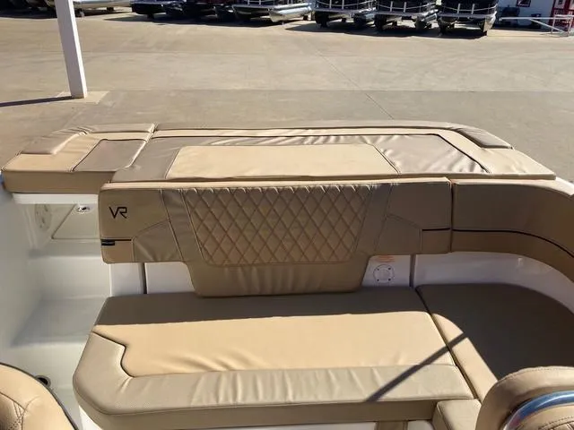 Slide: The Image of 2023 Bayliner VR5 boat interior with beige cushioned seating and diamond-stitched backrest. - 6