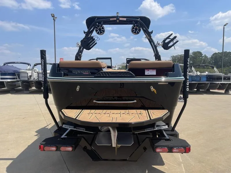 Slide: The Image of 2024 Moomba Craz boat rear view at a marina, showcasing swim platform and wakeboard tower. - 3