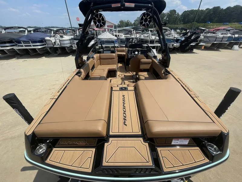 Slide: The Image of 2024 Moomba Craz boat with tan seating and modern design at a marina. - 4