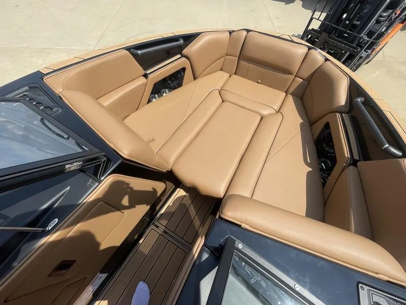 Slide: The Image of 2024 Moomba Craz boat interior with tan leather seating and wood flooring. - 8