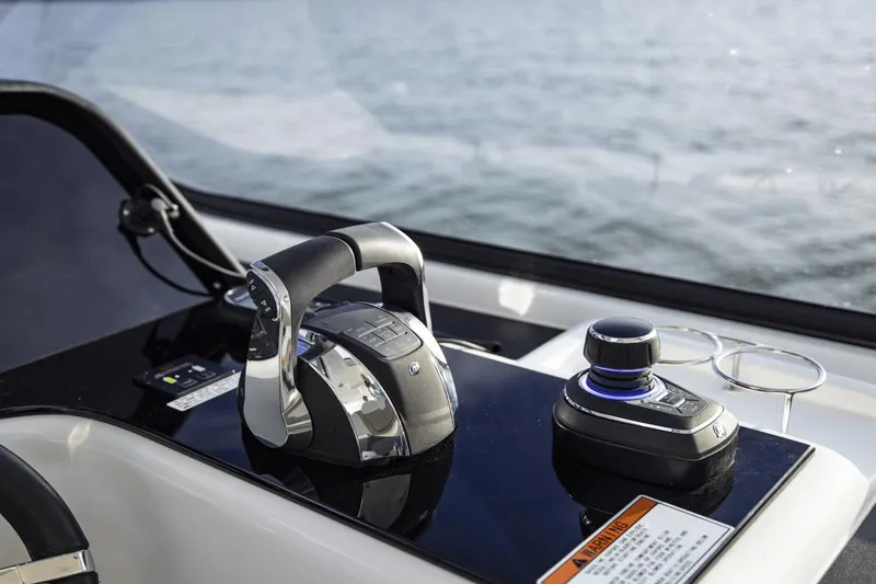 Slide: The Image of 2024 Aquila 36 Sport helm controls with throttle and joystick on a sleek dashboard. - 14