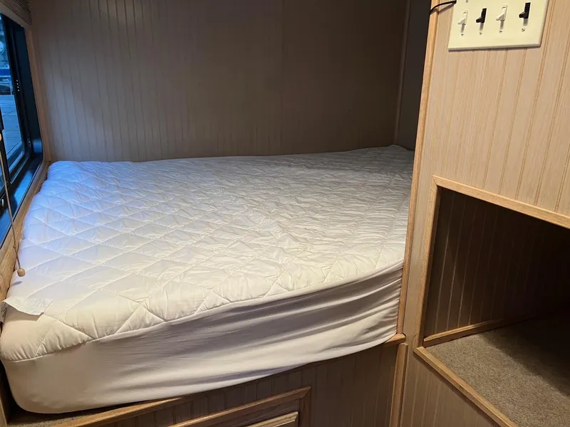 Slide: The Image of Custom 1998 Escalante Share #8 RV interior with a cozy bed and storage shelves. - 11