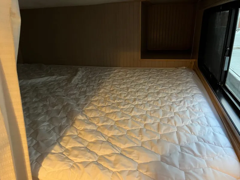 Slide: The Image of 1998 Custom Escalante Share #8 RV bed with quilted mattress and window view. - 12
