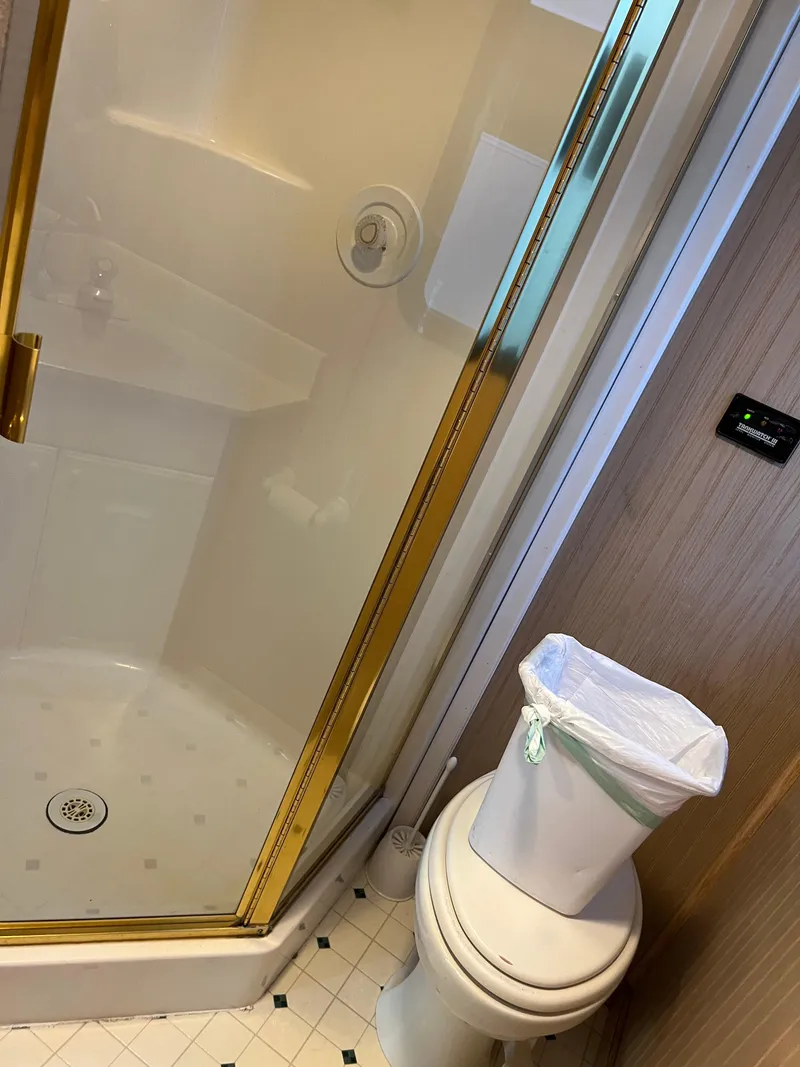 Slide: The Image of Bathroom with glass shower, toilet, and trash can, Custom Escalante share #8, 1998 model. - 13