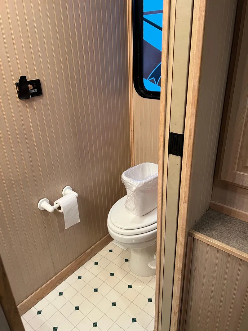 Slide: The Image of 1998 Custom Escalante Share #8 RV bathroom with toilet, window, and toilet paper holder. - 16
