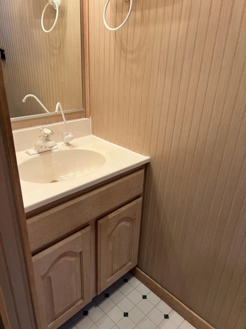 Slide: The Image of Small bathroom vanity with wooden cabinet, mirror, and beige wallpaper, Custom Escalante share #8, 1998. - 17