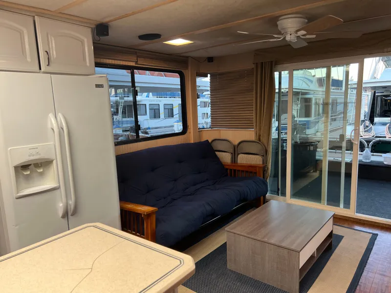 Slide: The Image of Houseboat interior with futon, coffee table, refrigerator, and sliding glass door, Custom Escalante share #8, 1998. - 4