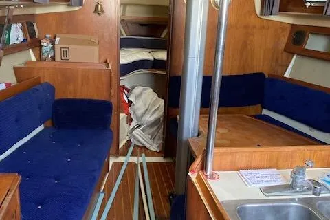 Slide: The Image of Interior of a 1985 Pearson 36-2 sailboat with blue seating and wooden finishes. - 8