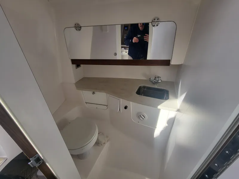 Slide: The Image of 2018 Everglades 360 LXC boat bathroom with sink, toilet, and mirror. - 28